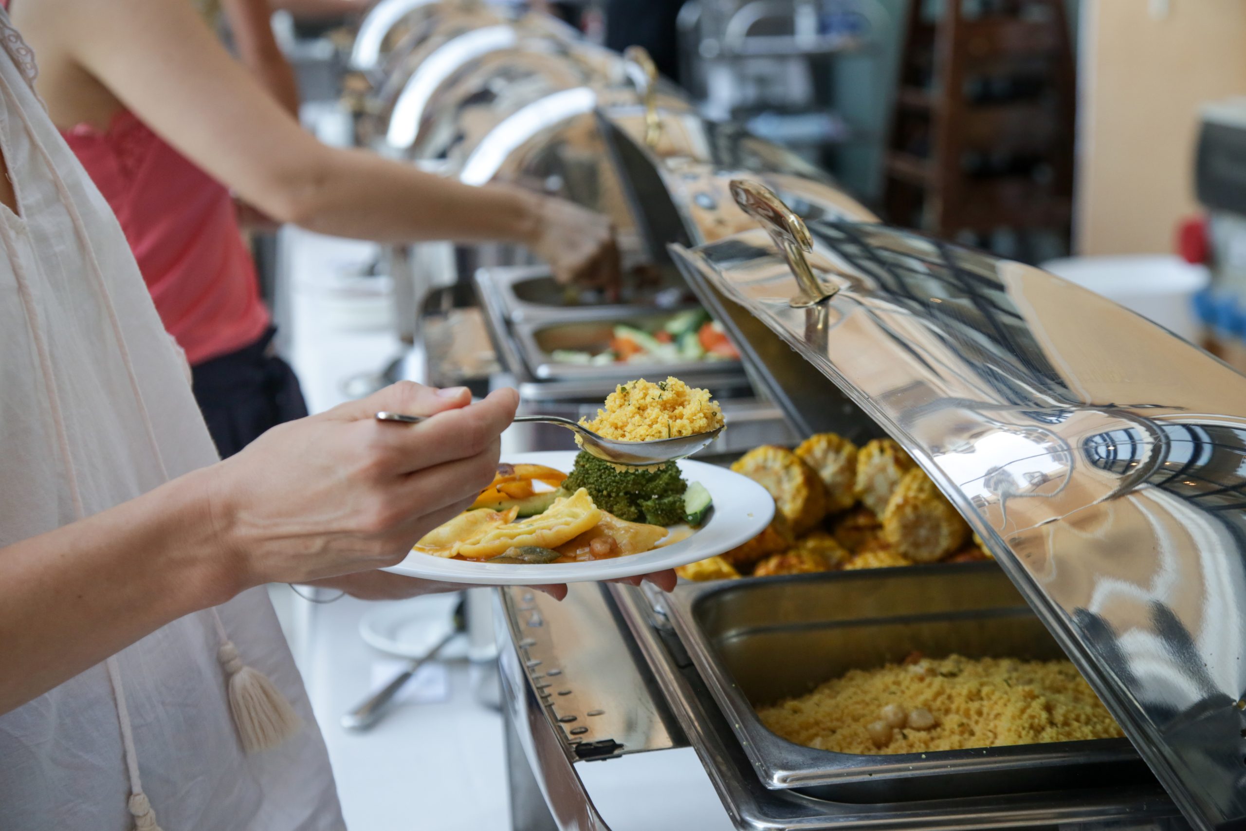 Woman taking food from a buffet line Woman taking food from a buffet line